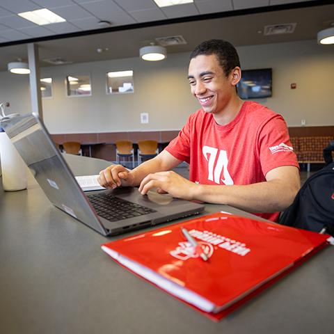 Student in the classroom taking notes  on their laptop